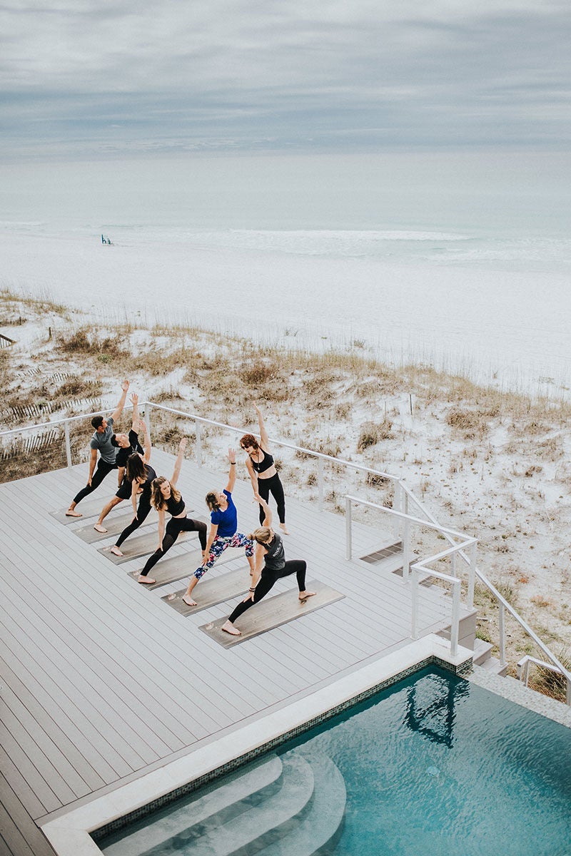 instructor and yoga class on the deck of beach home on the Emerald Coast