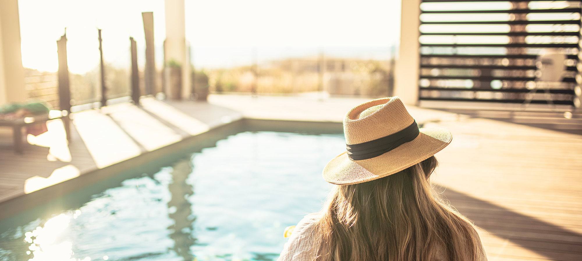 Girl in hat with pool in background
